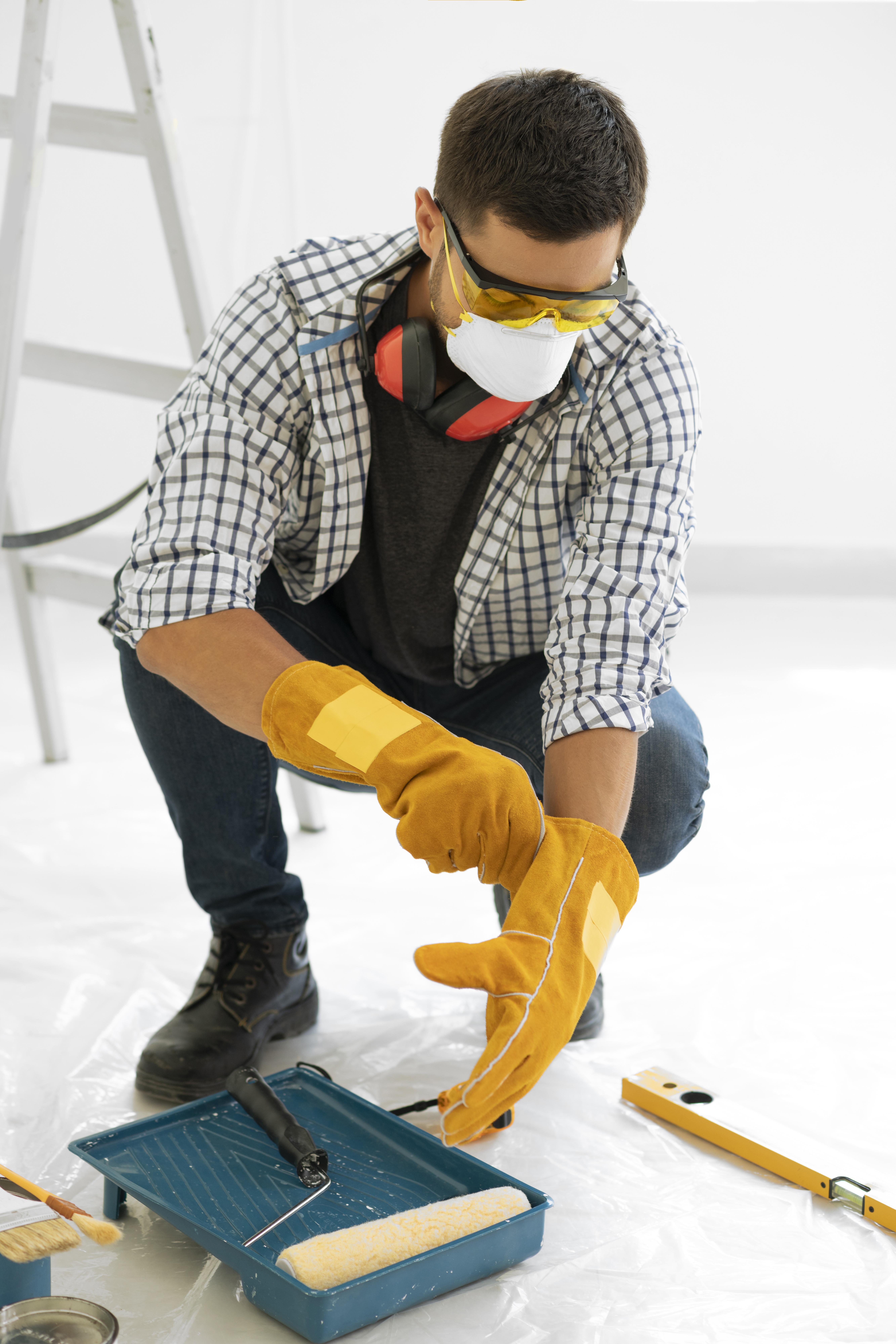 Professional painter with safety equipment maintaining clean workspace